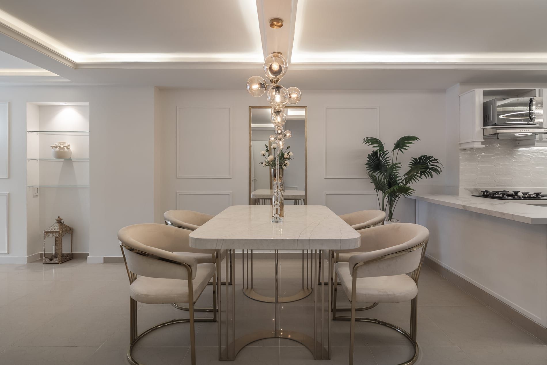 Mesa de comedor blanca con sillas tapizadas bajo un cielorraso con luz perimetral
